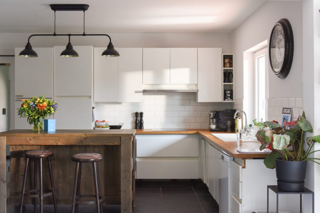 Keuken met witte kasten en keukeneiland in hout