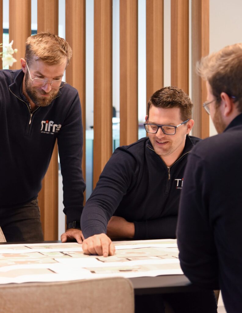 drie collega's bestuderen een bouwplan